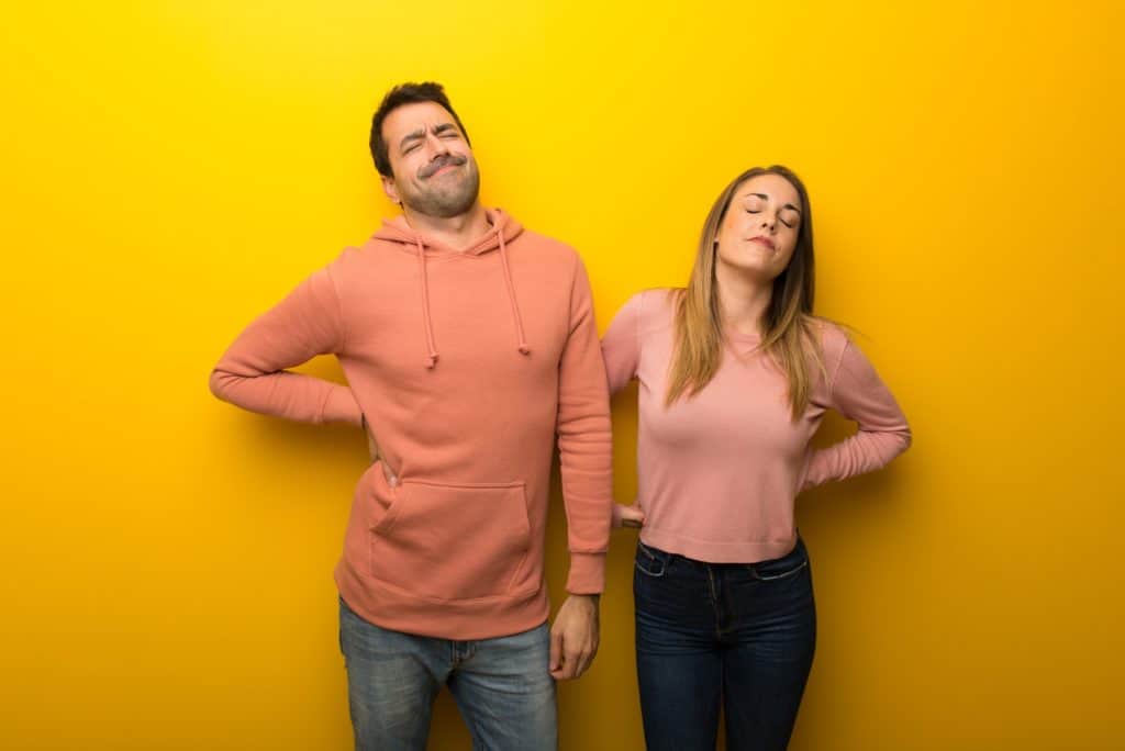 man and woman suffering from chronic back pain