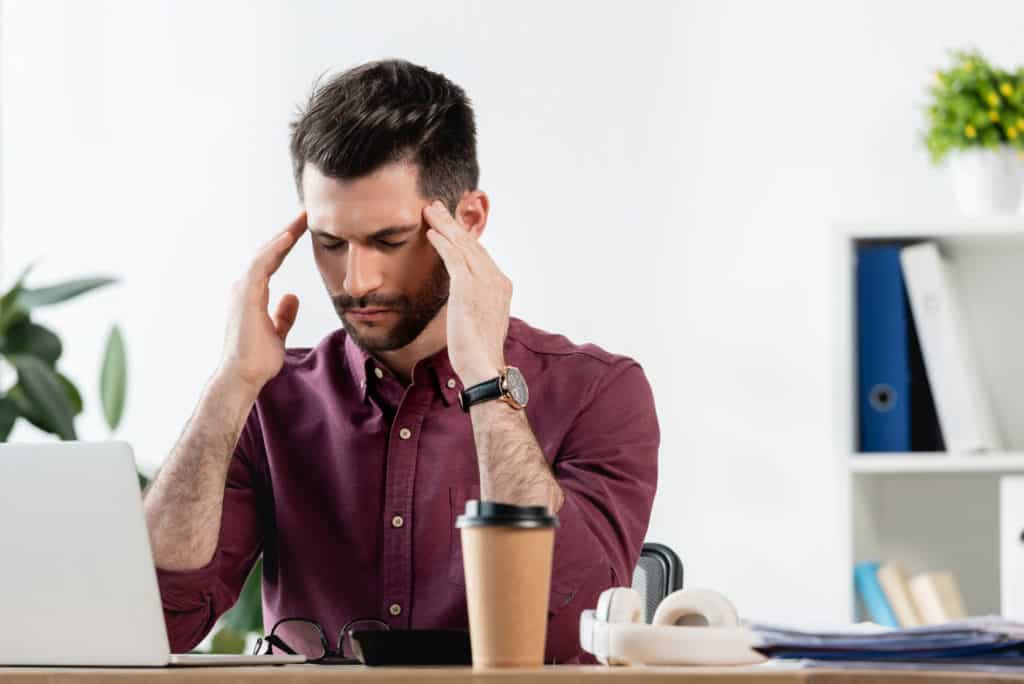 male headache sufferer at work 